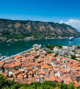 Red-roofed old town on a bay surrounded by mountains, seen from above