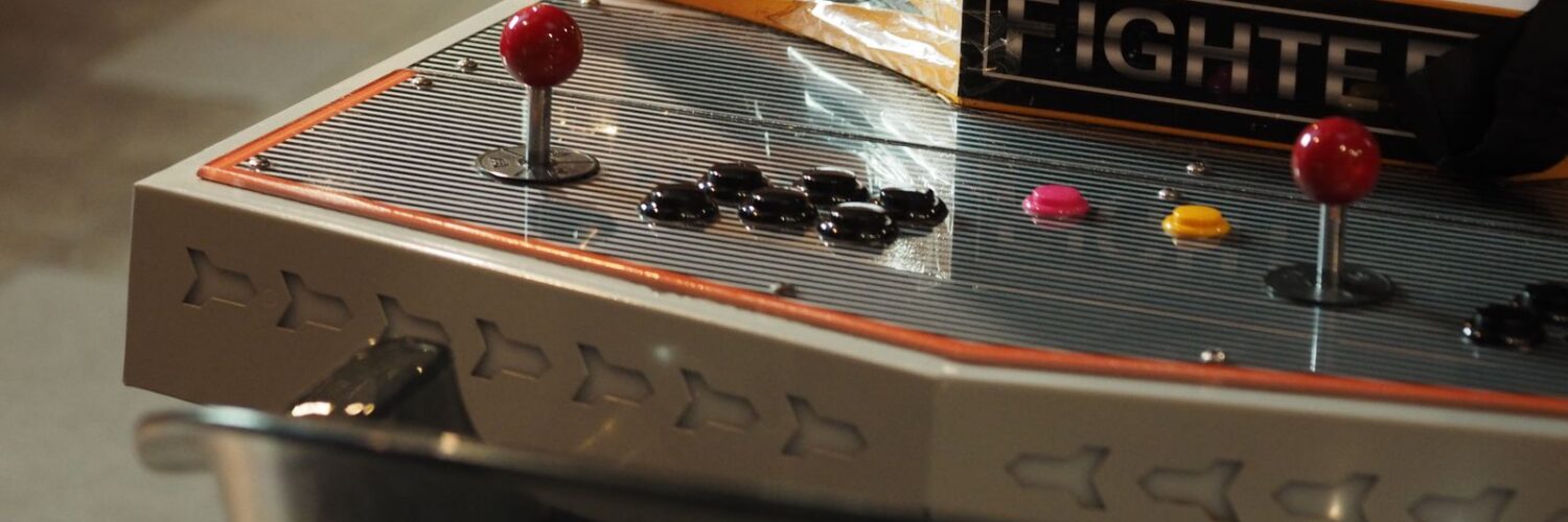 Close-up of an old-style arcade control panel with joysticks and push buttons