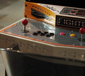 Close-up of an old-style arcade control panel with joysticks and push buttons