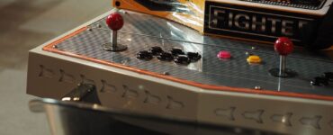 Close-up of an old-style arcade control panel with joysticks and push buttons
