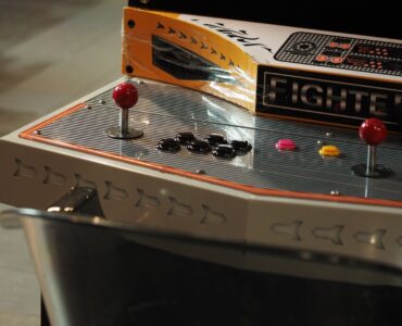 Close-up of an old-style arcade control panel with joysticks and push buttons