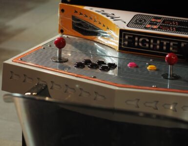 Close-up of an old-style arcade control panel with joysticks and push buttons