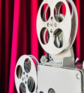 Vintage film projector in front of a red curtain