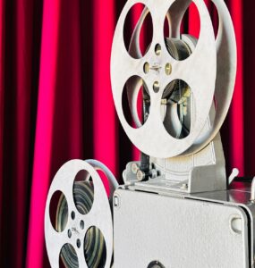 Vintage film projector in front of a red curtain