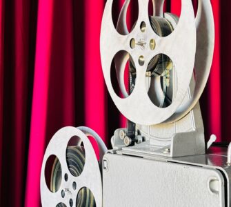 Vintage film projector in front of a red curtain