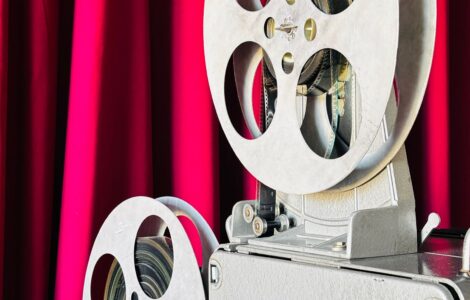 Vintage film projector in front of a red curtain
