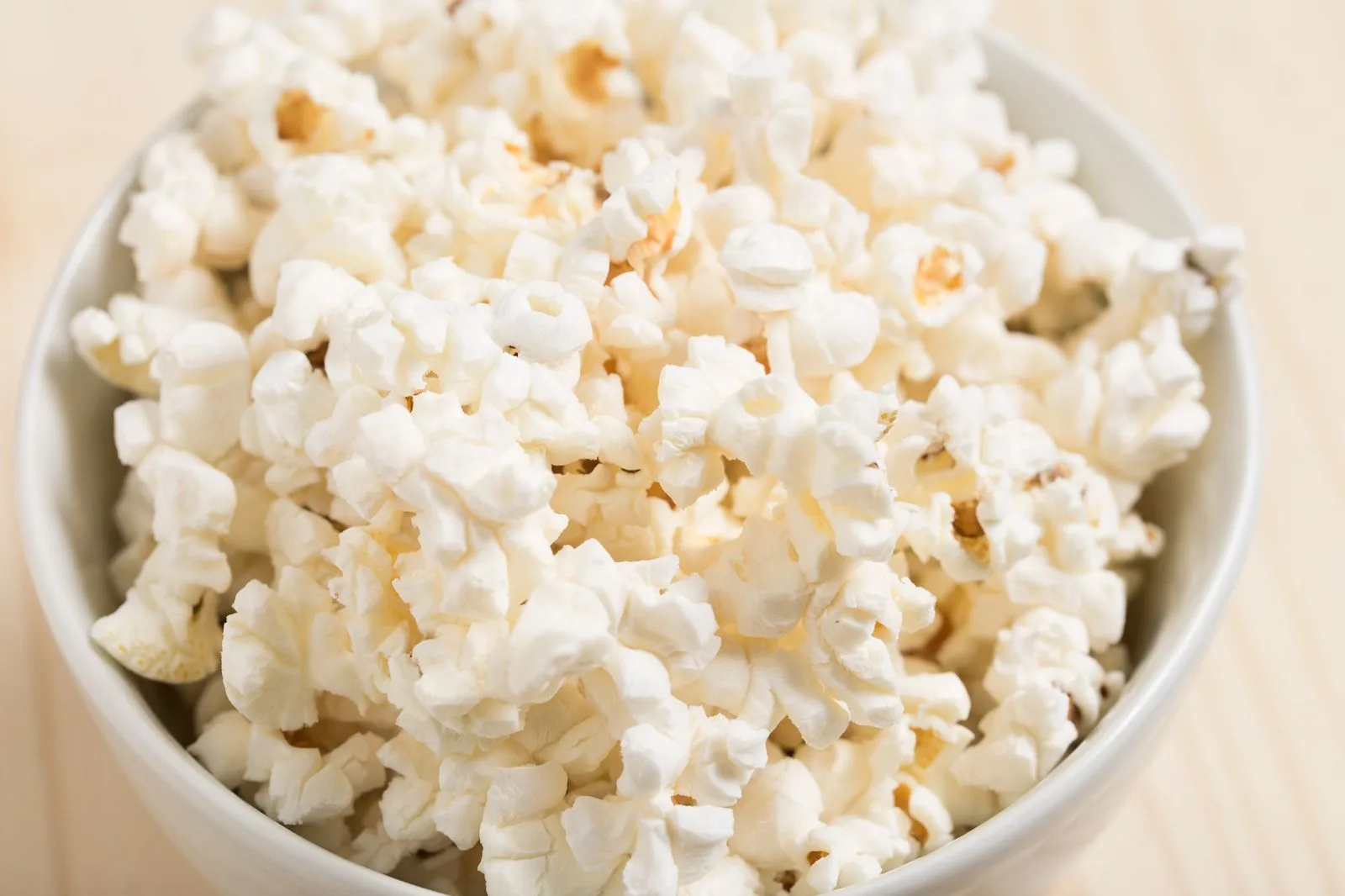Freshly popped popcorn in a white bowl